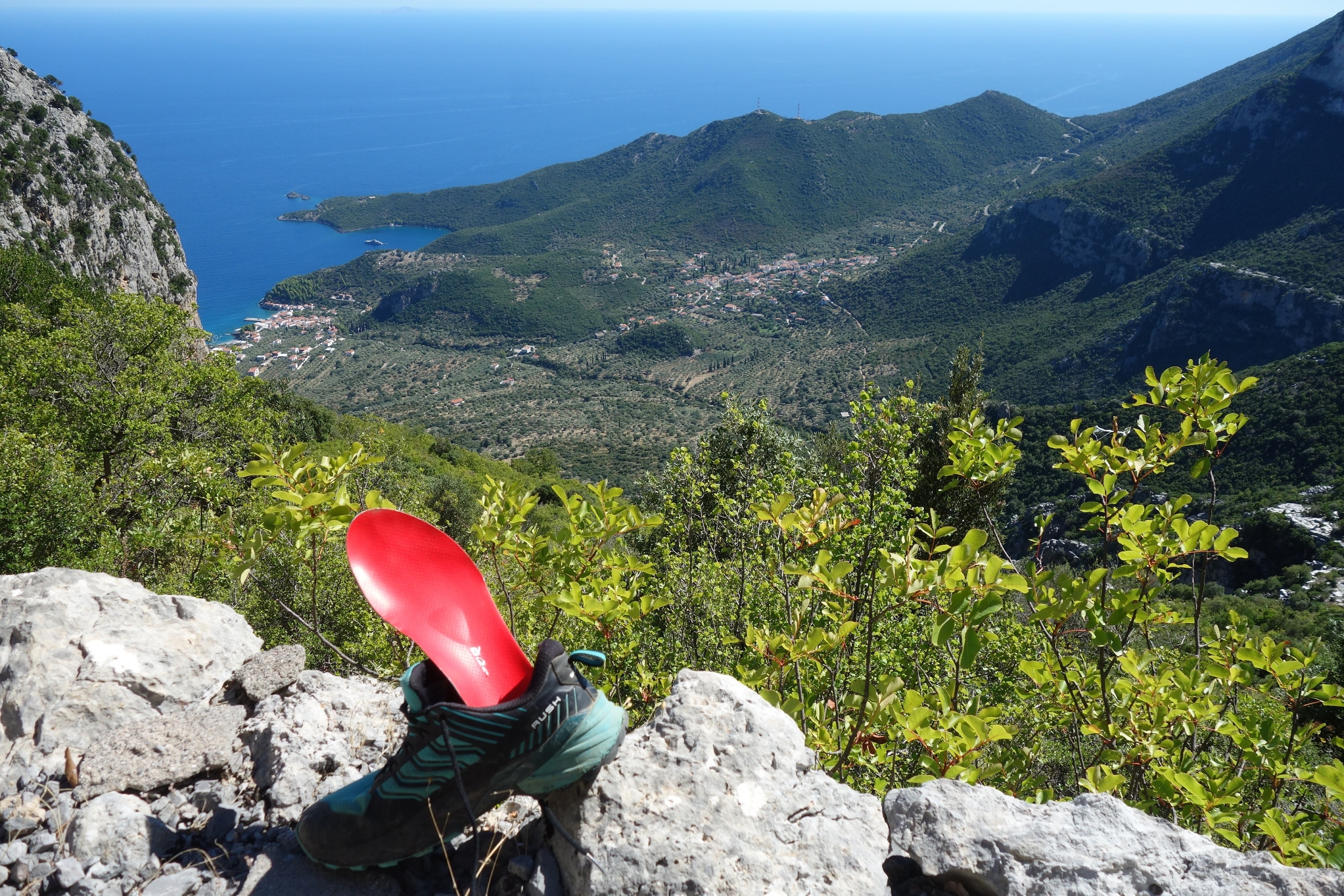 Schuh mit Sohle im Vordergrund mit Bergen und Meer
