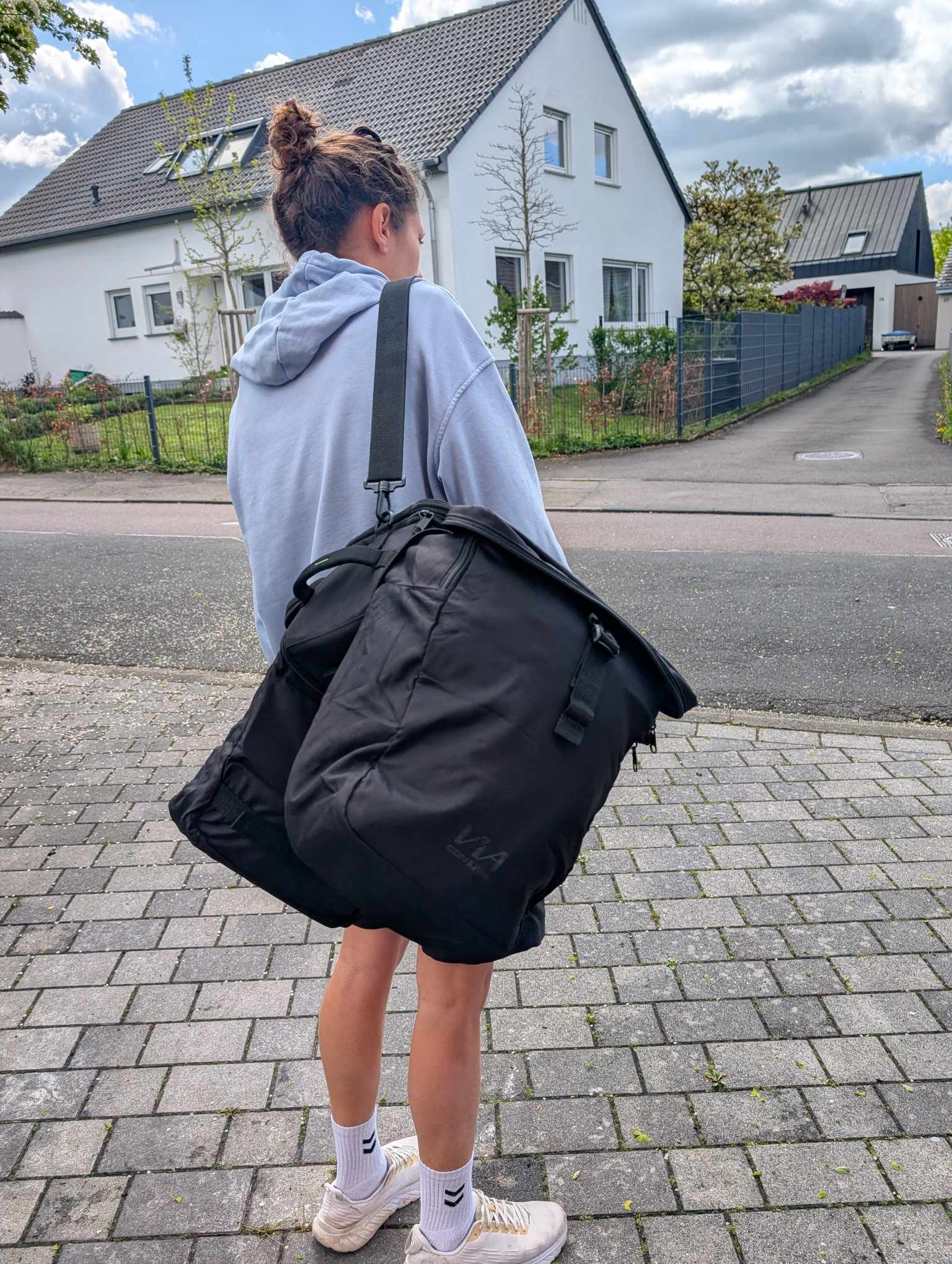 Jemand trägt die Tasche mit dem Schultergurt 