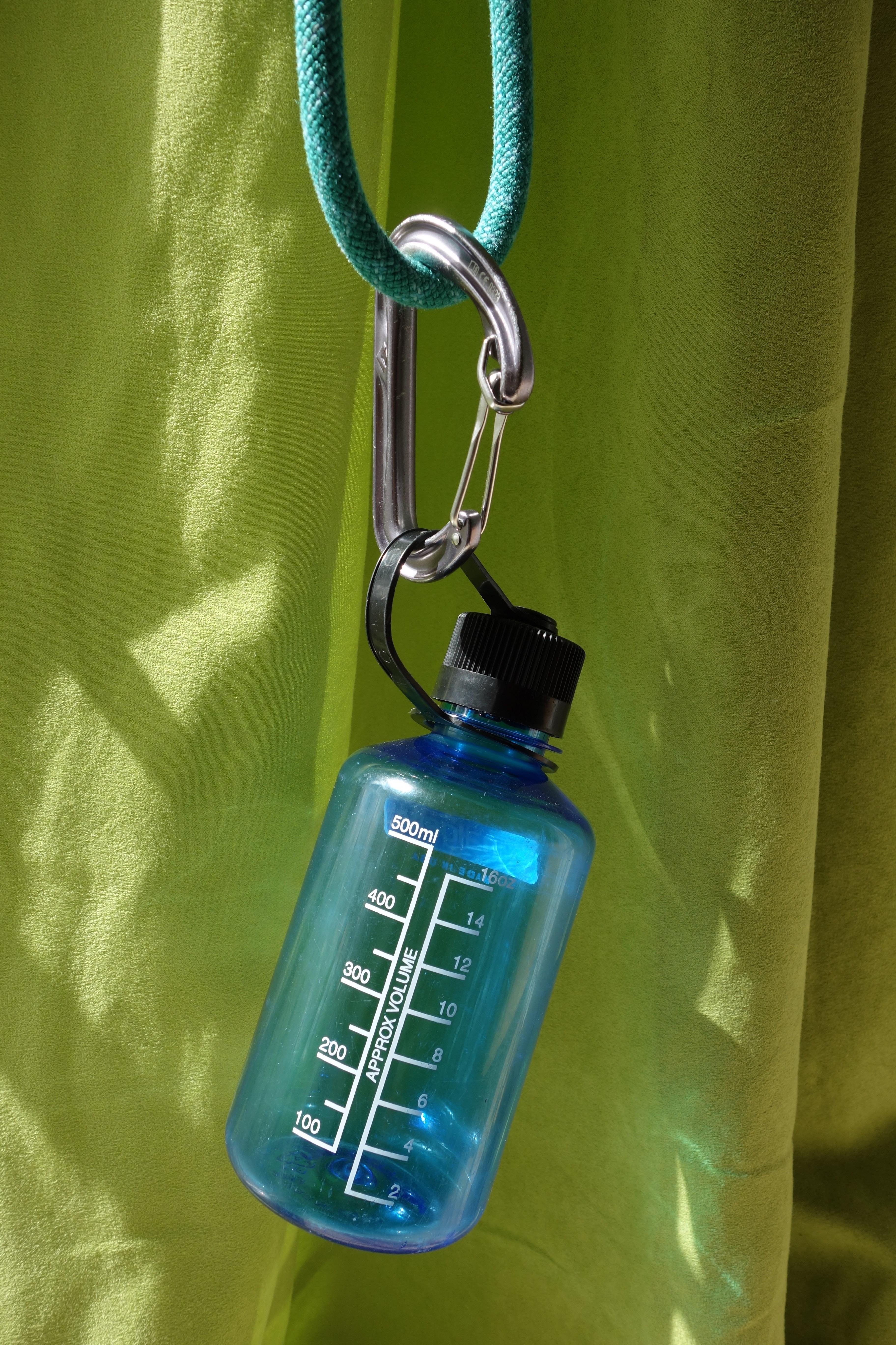 Die Flasche, hängend an einem Karabiner an einem Seilstück