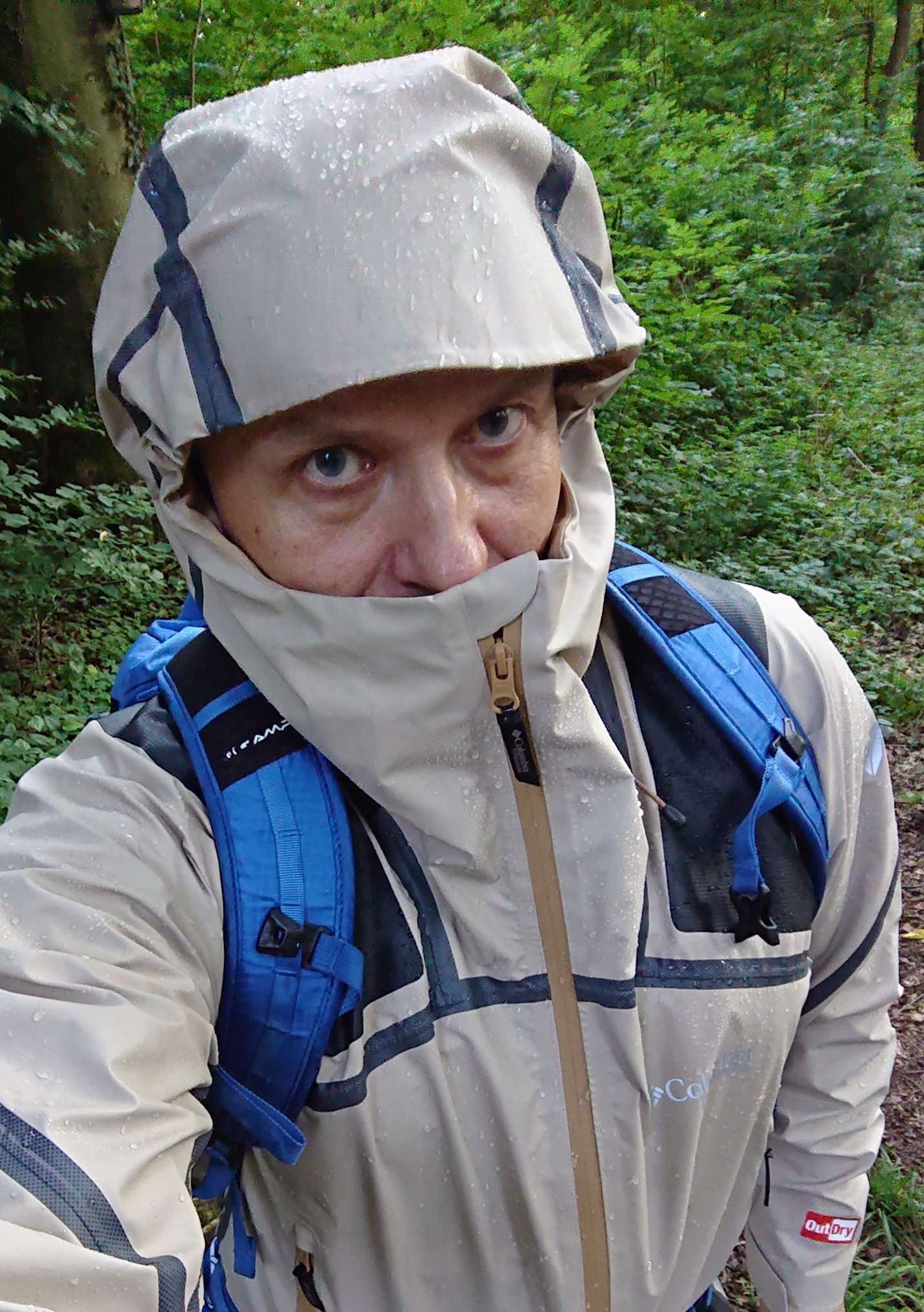 grimmig dreinschauender Typ mit Regenjacke