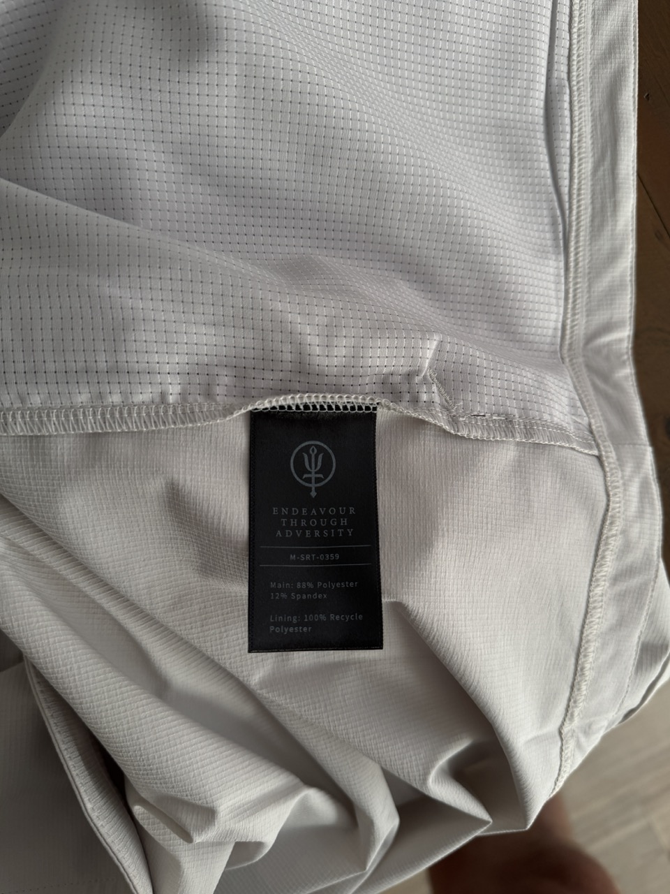 Materialmix (88% Polyester, 12% Spandex). Darüber sind die Meshtaschen zu sehen