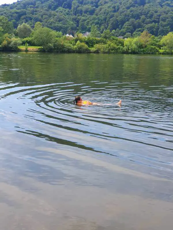 Man sieht jemanden der mit der Boje auf dem Rücken treibt