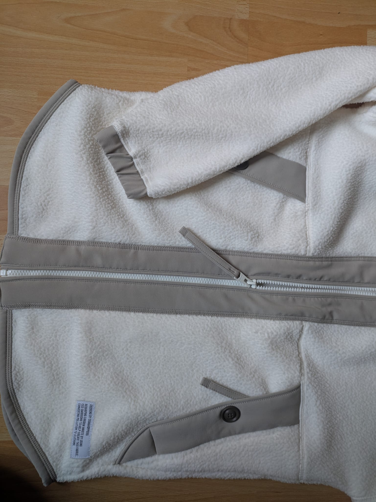 Zu sehen sind die zwei Taschen mit Reißverschluss und Druckknopf und der mittig angebrachte Reißverschluss. 