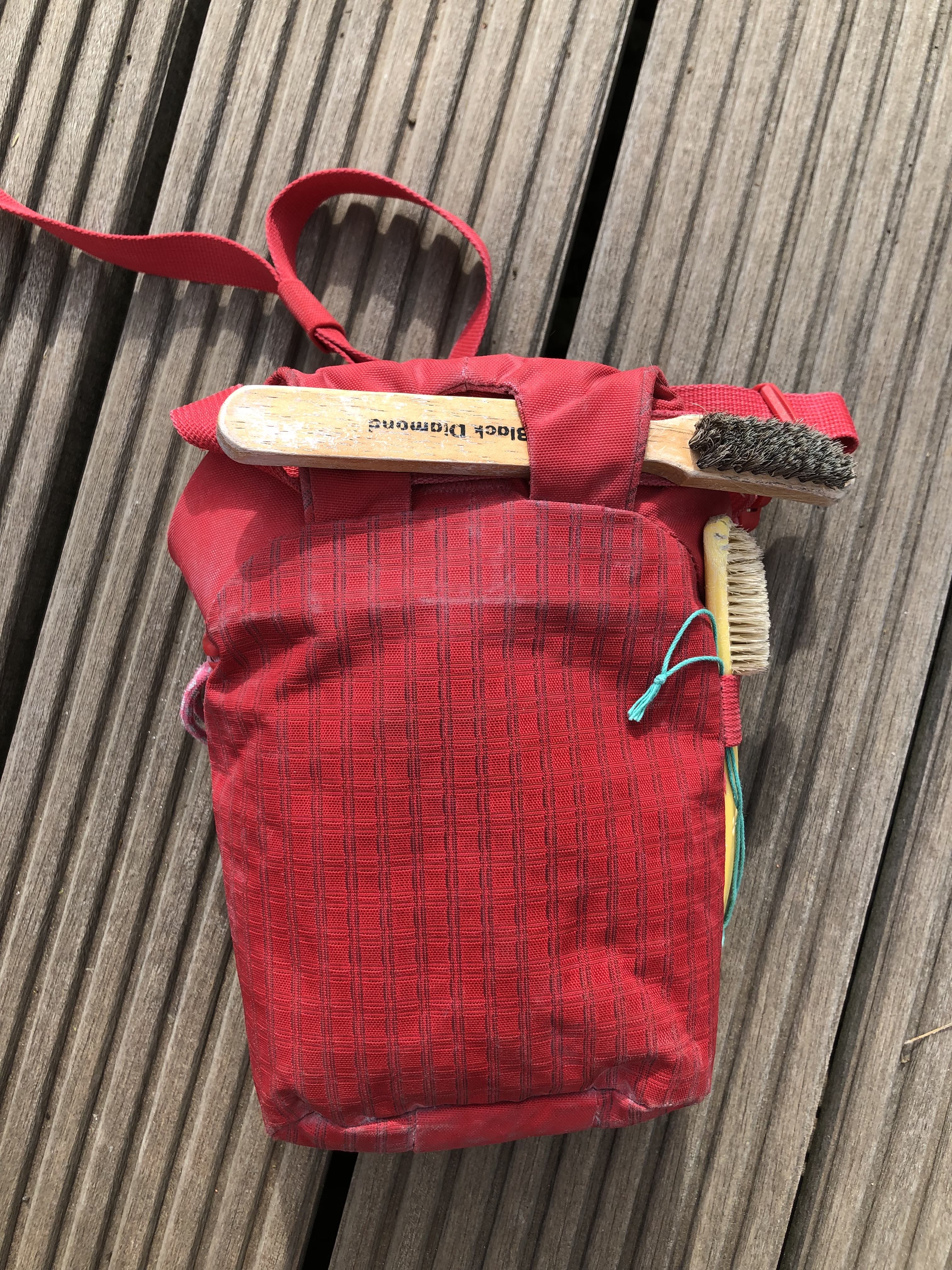 Man kann die dickere Holzbürste nur an der Halterung für das Gurtband verstauen
