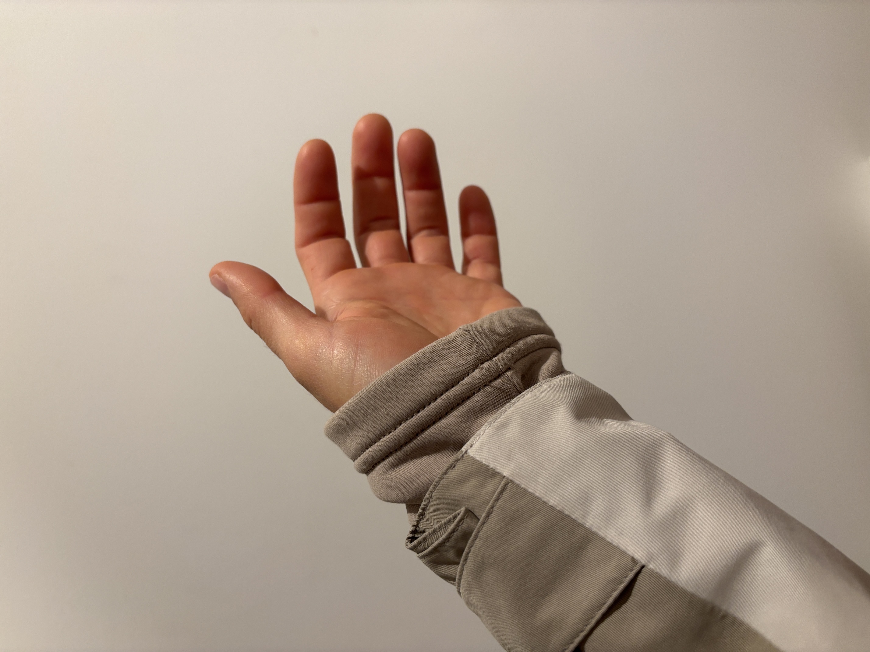 Der Ärmel der Isolationsjacke schaut unter der Regenjacke heraus