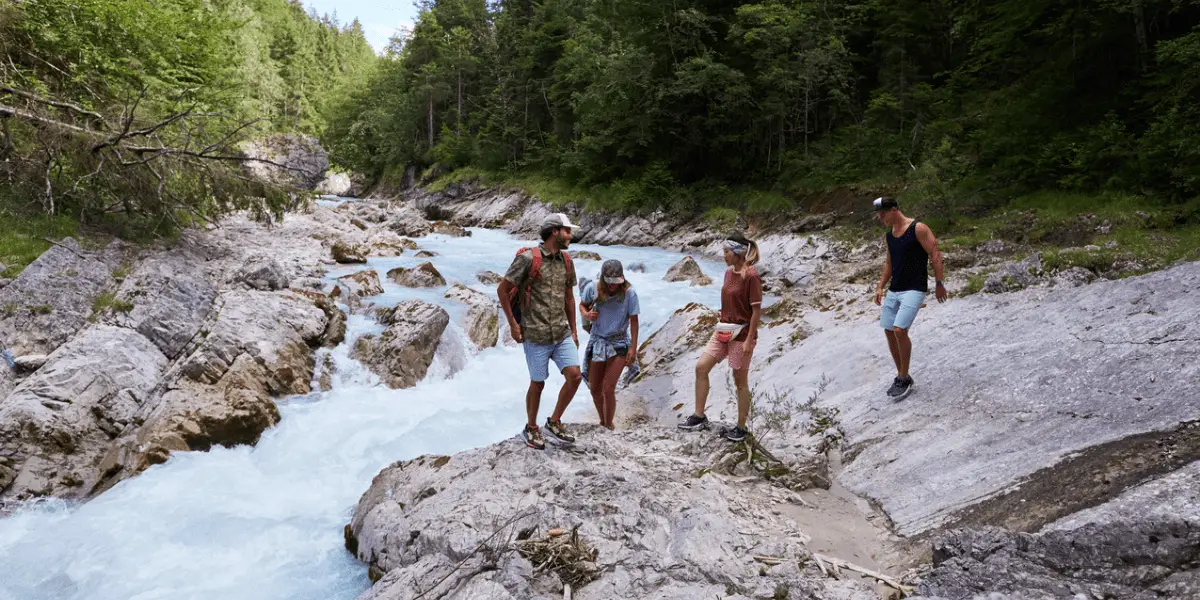  OUTSIDEstories Ratgeber Sonnenschutz beim Camping-Urlaub und auf Reisen, Wanderer am Fluss
