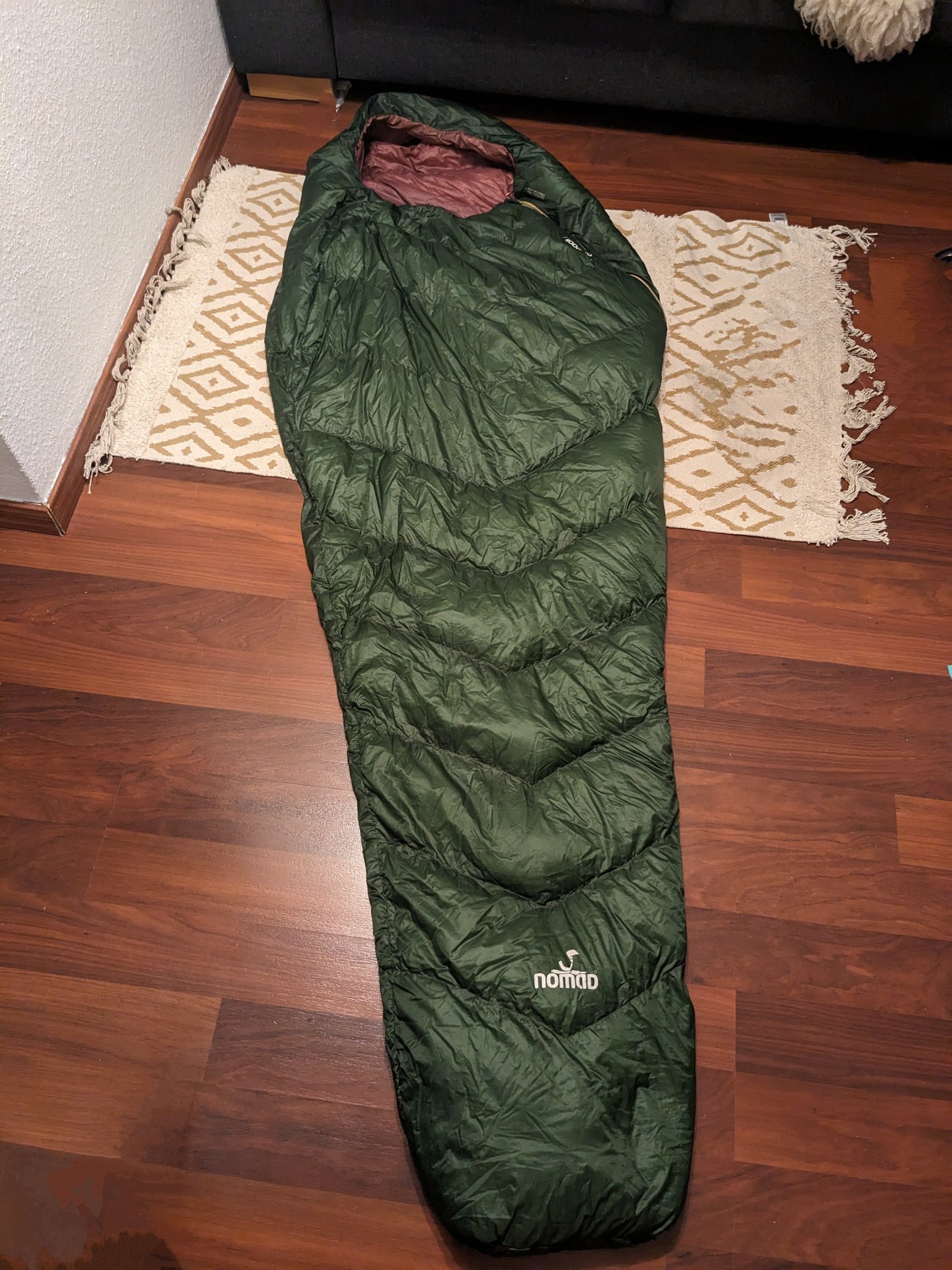 Der Schlafsacks liegt auf dem Boden. Er hat eine klassische Mumienform 