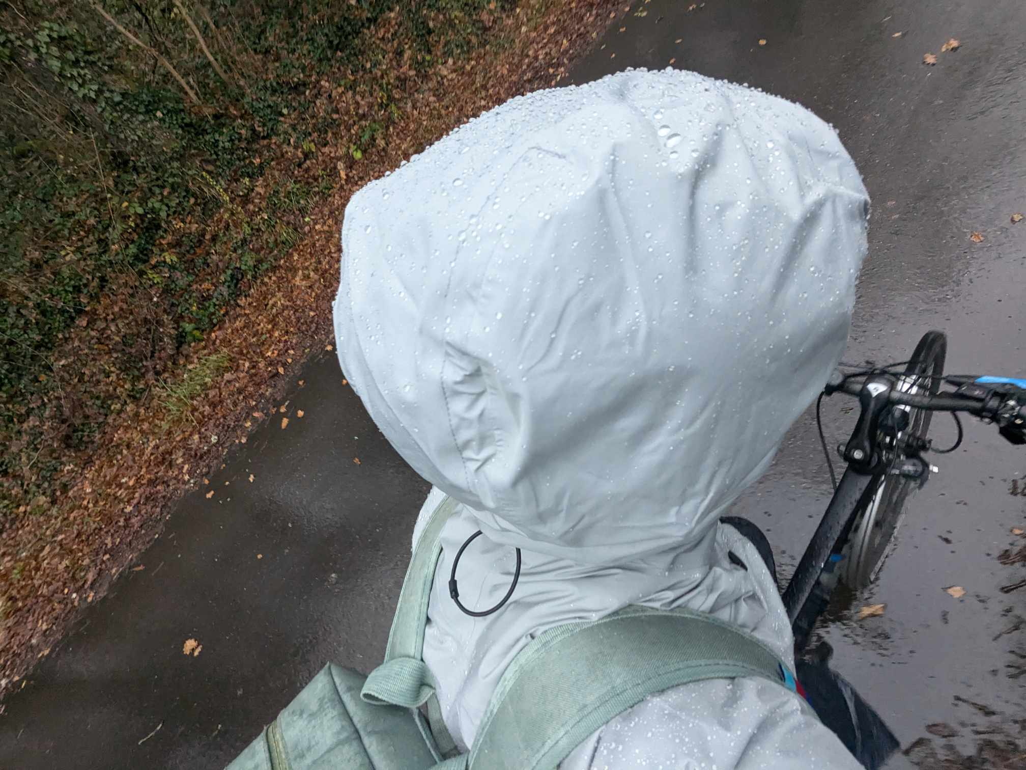 Man sieht jemanden im Regen mit der Kapuze auf dem kopf