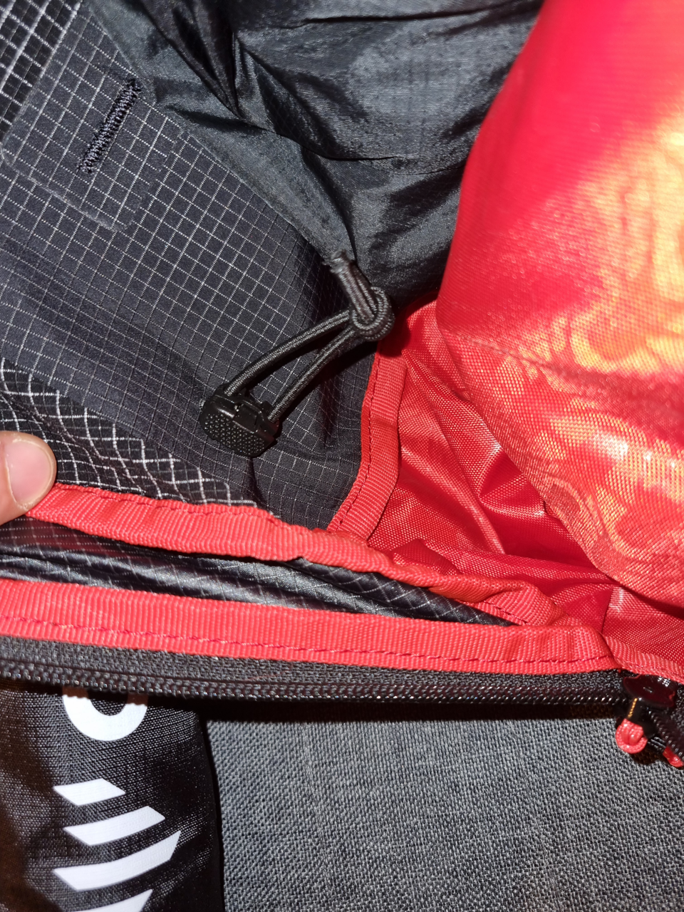 Gummiband um die Eispickelhalter bündig an den Rucksack zu ziehen.