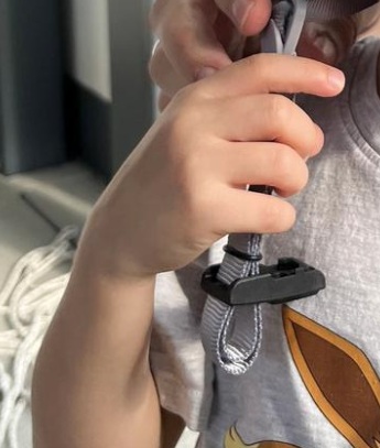 ein Ende des Magnetverschlusses in Relation zur Kinderhand zu sehen