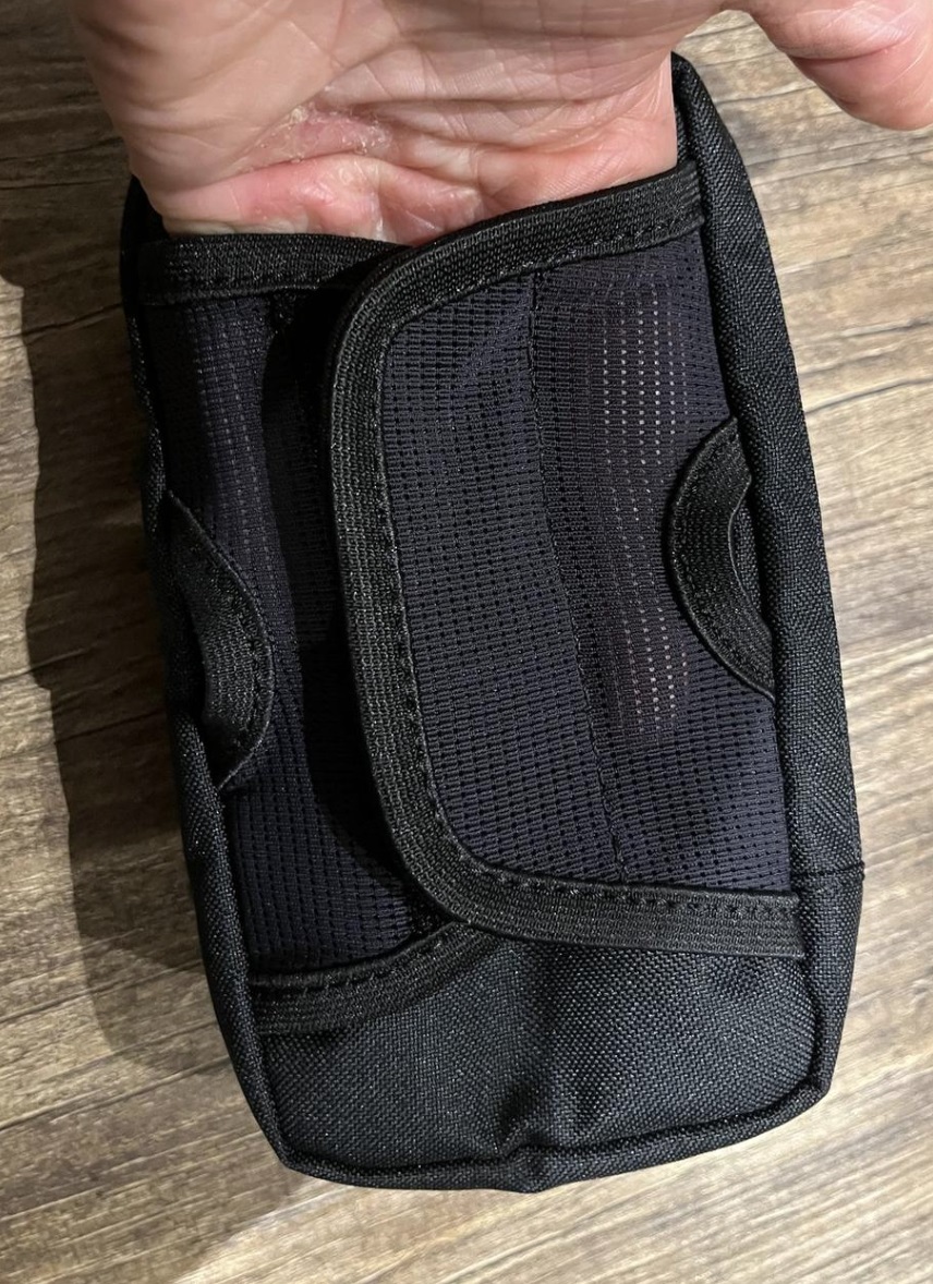 mit der Hand den Netzstoff am Klettverschluss zeigend