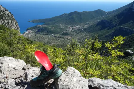 Schuh mit Sohle im Vordergrund mit Bergen und Meer