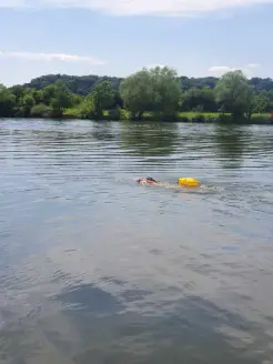 Mam sieht eine Schwimmerin die eine Schwimmboje zieht. Man sieht die Boje sehr gut