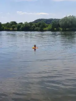 Jemand hängt mit den Armen über der Boje