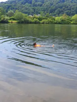 Man sieht jemanden der mit der Boje auf dem Rücken treibt