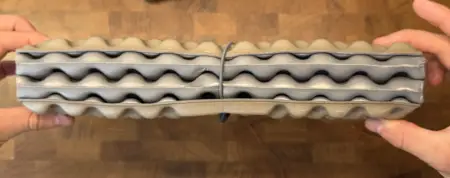 Man stelle sich Gummizüge statt Händen vor und es wären 2cm eingespart worden.
